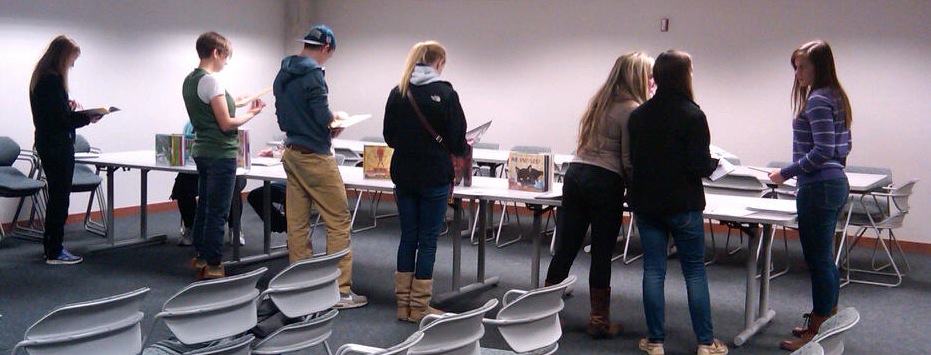 People reading picture books, at the Mock Caldecott, Manhattan, KS, 7 Dec. 2013